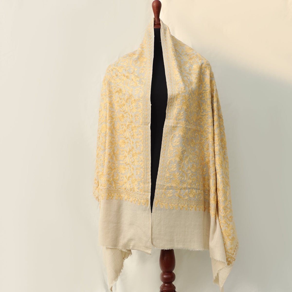 Aari pattern yellow colored kashmiri embroidery on pashmina wool in light beige base color; Intricate machine embroidery all across the shaw